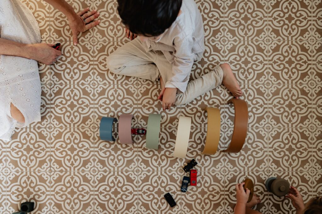 Enfants qui jouent au sol, photo de famille à domicile à Marseille 13007.