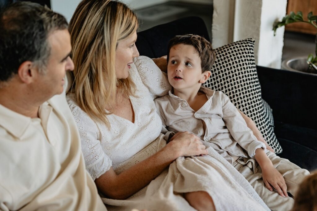 Famille sur un canapé dans un intérieur lumineux, séance photo famille à domicile à Marseille.