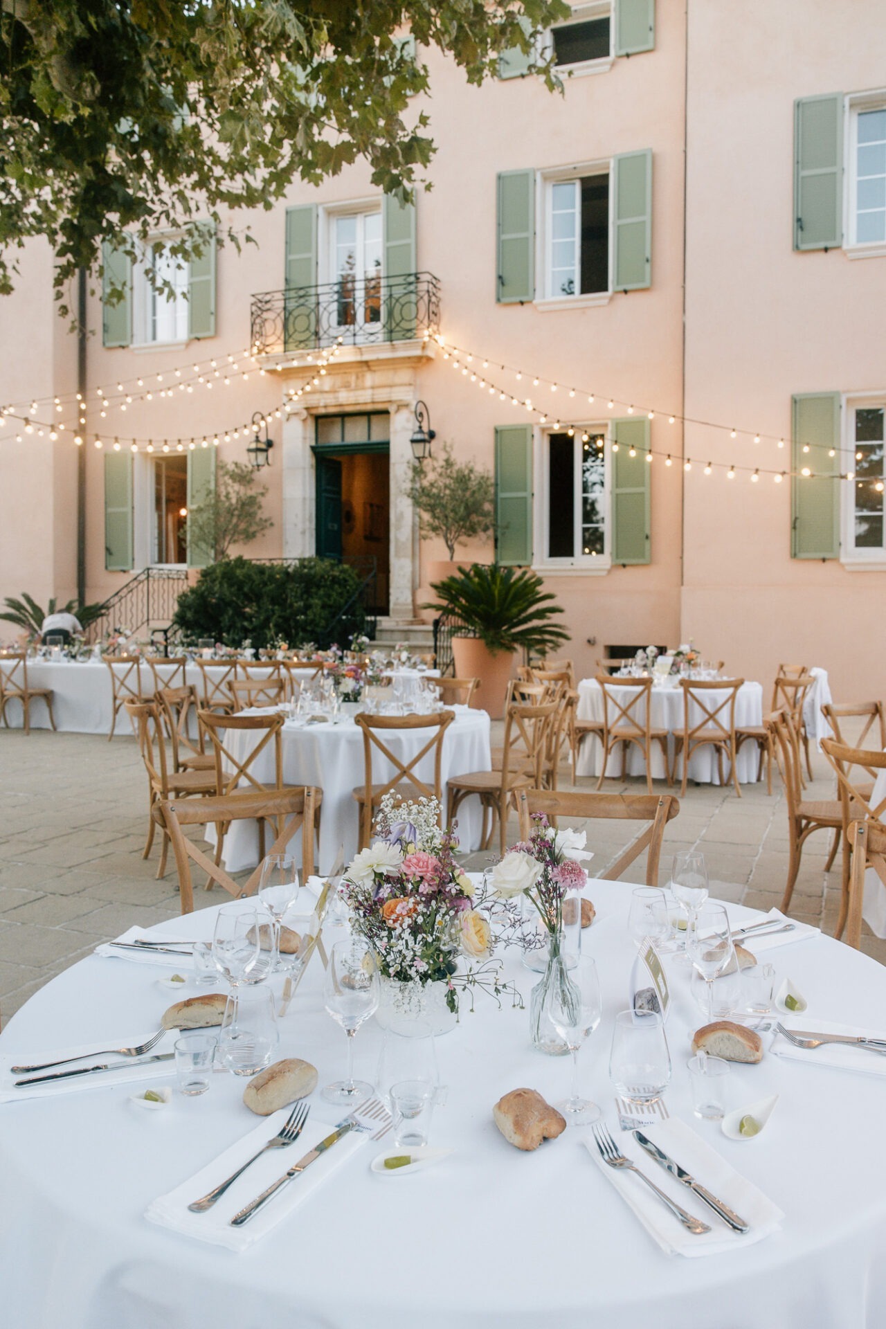 Dîner de mariage dans la cour du Château des Anglades à Hyères dans le Var devant la façade du domaine