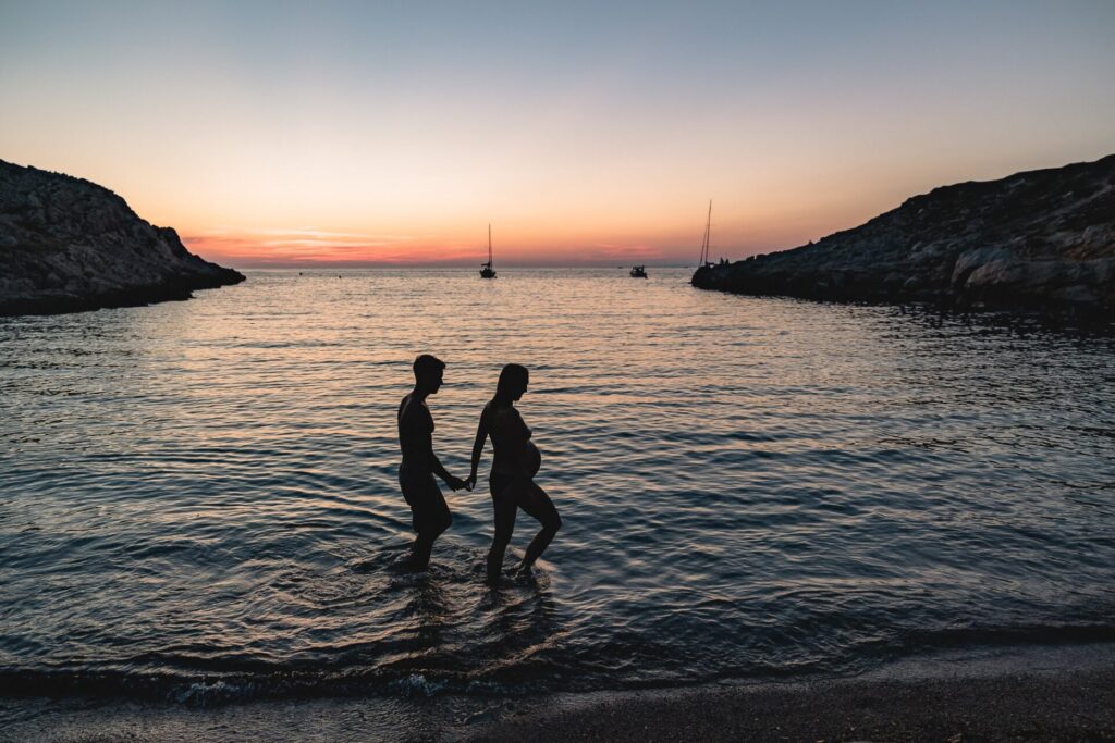 silhouettes couple enceinte dans la mer au coucher du soleil aux Goudes