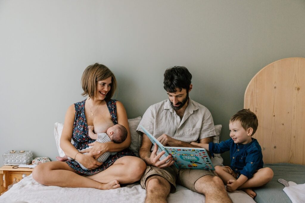 Séance photo famille avec nouveau-né et grand frère sur le lit parents à L'Estaque