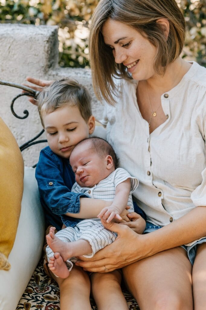Maman avec son grand garçon et son nouveau-né dans les bras, séance photo fratrie à Marseille