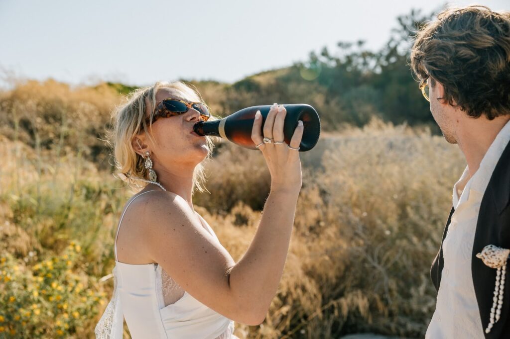 Mariée buvant du champagne dans les calanques pendant un mariage intime à Marseille