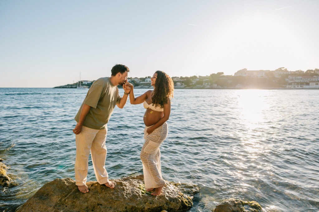 couple sur un rocher pendant une séance photo grossesse en bord de mer