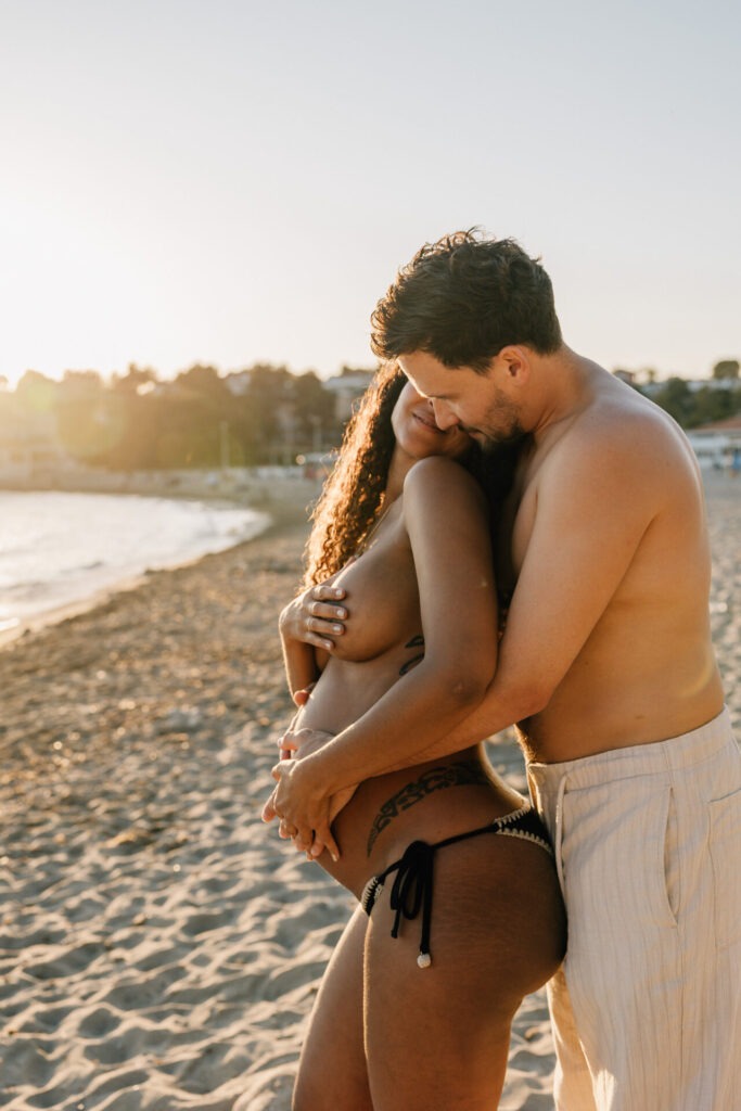 couple enlacé au coucher du soleil pendant une séance photo grossesse à Carry-le-Rouet