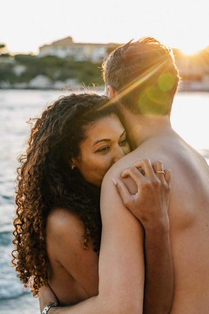 couple amoureux enlacé pendant une séance grossesse au coucher du soleil