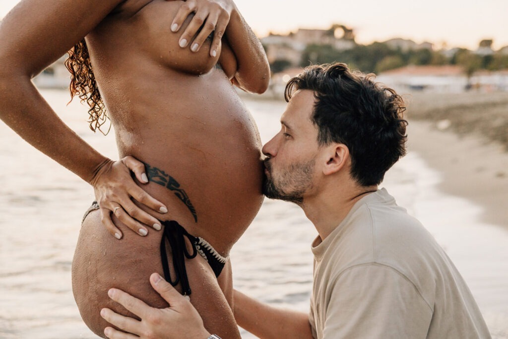 futur papa embrassant le ventre de femme enceinte pendant une séance grossesse