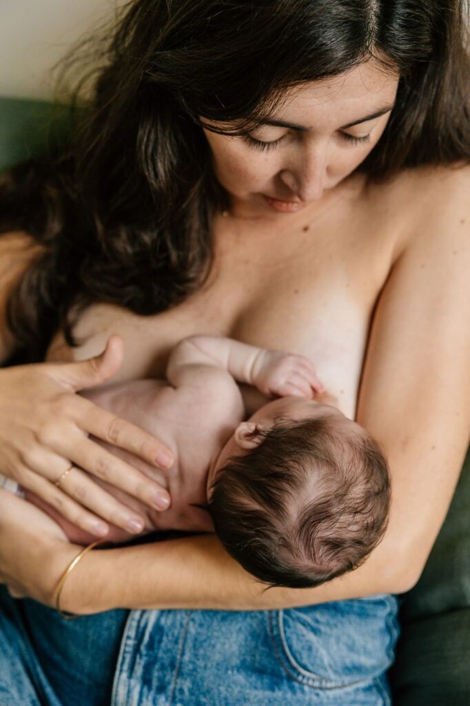 maman tenant son bébé contre elle en peau à peau lors d'une séance photo nouveau-né Marseille lumière naturelle