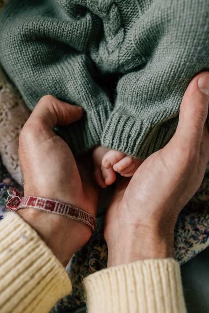 bébé nouveau-né dans les mains de son papa photographie naissance
