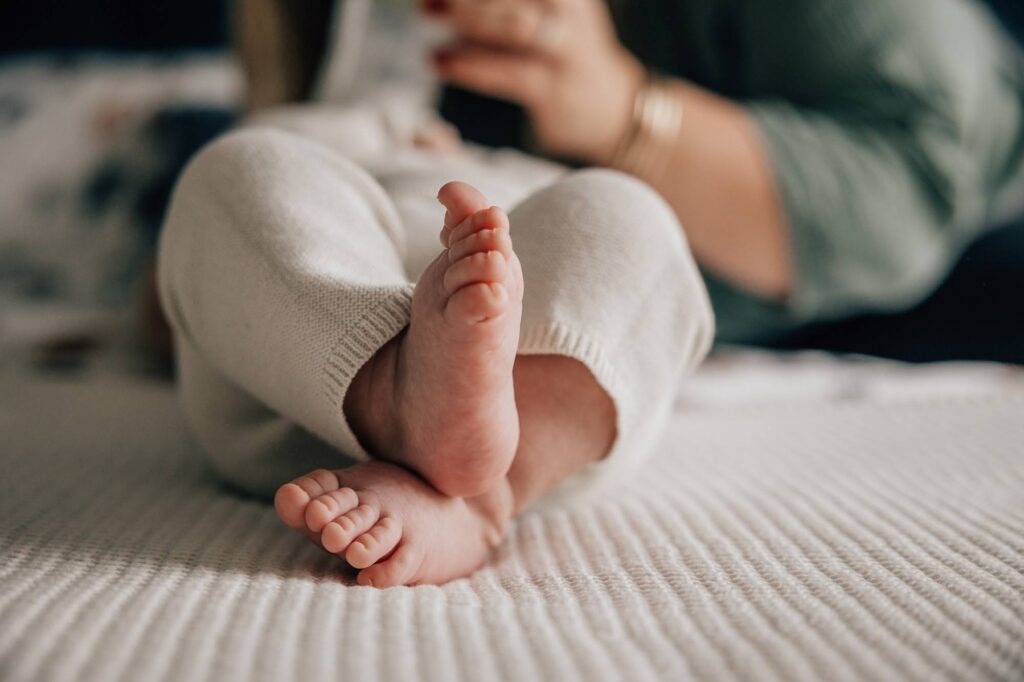 Gros plan sur les pieds d'un bébé de 3 mois lors d'une séance photo à domicile
