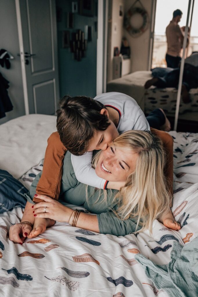 Maman et son fils aîné enlacés sur le lit, séance photo famille à domicile Marseille