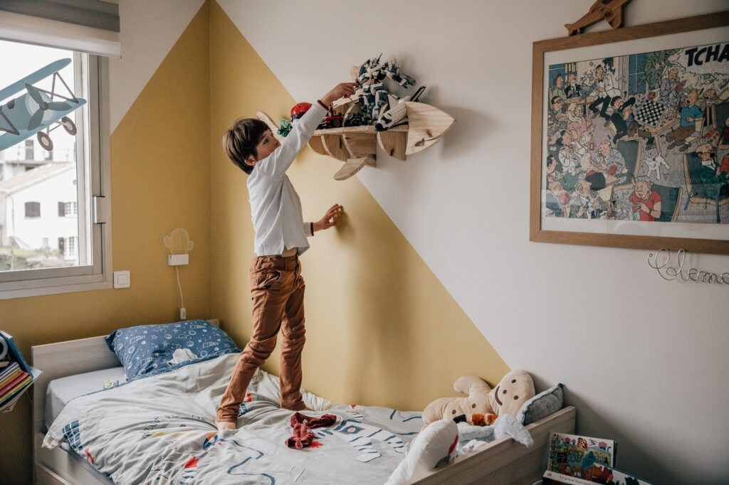 Grand frère dans sa chambre lors d'une séance photo famille à Marseille