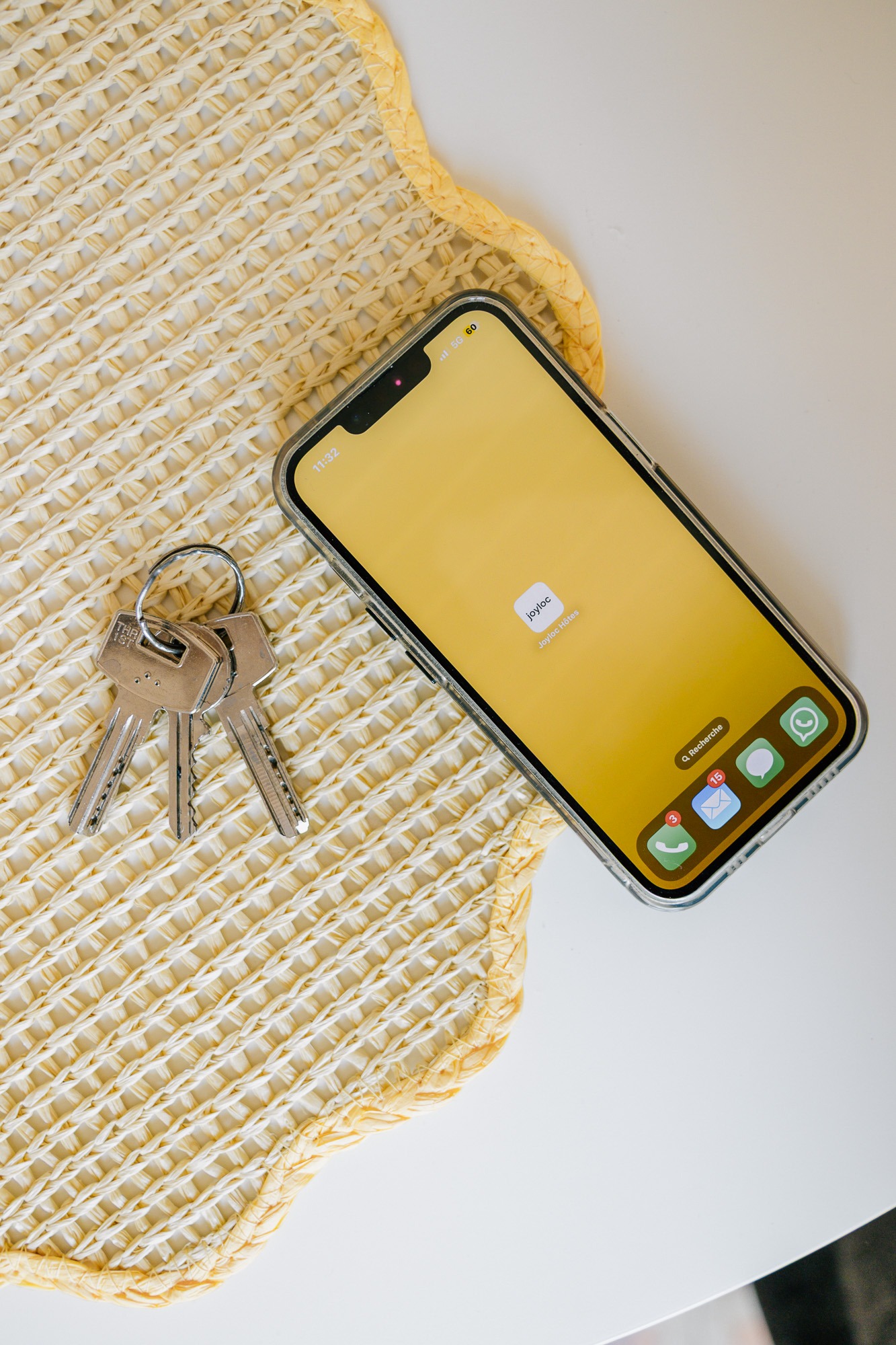 Smartphone avec l'application Joyloc et trousseau de clés sur une table